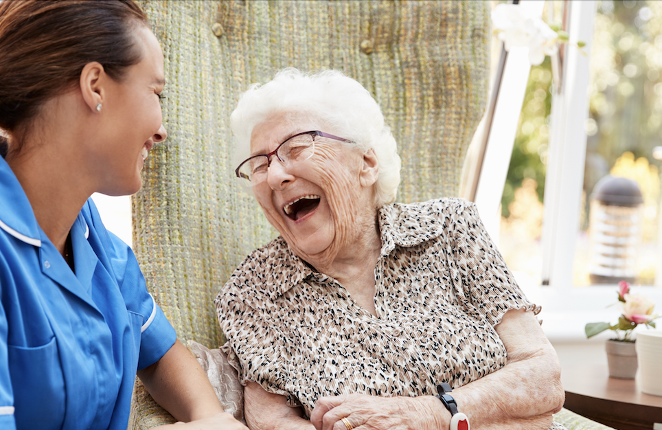 elderly woman laughing with nurse