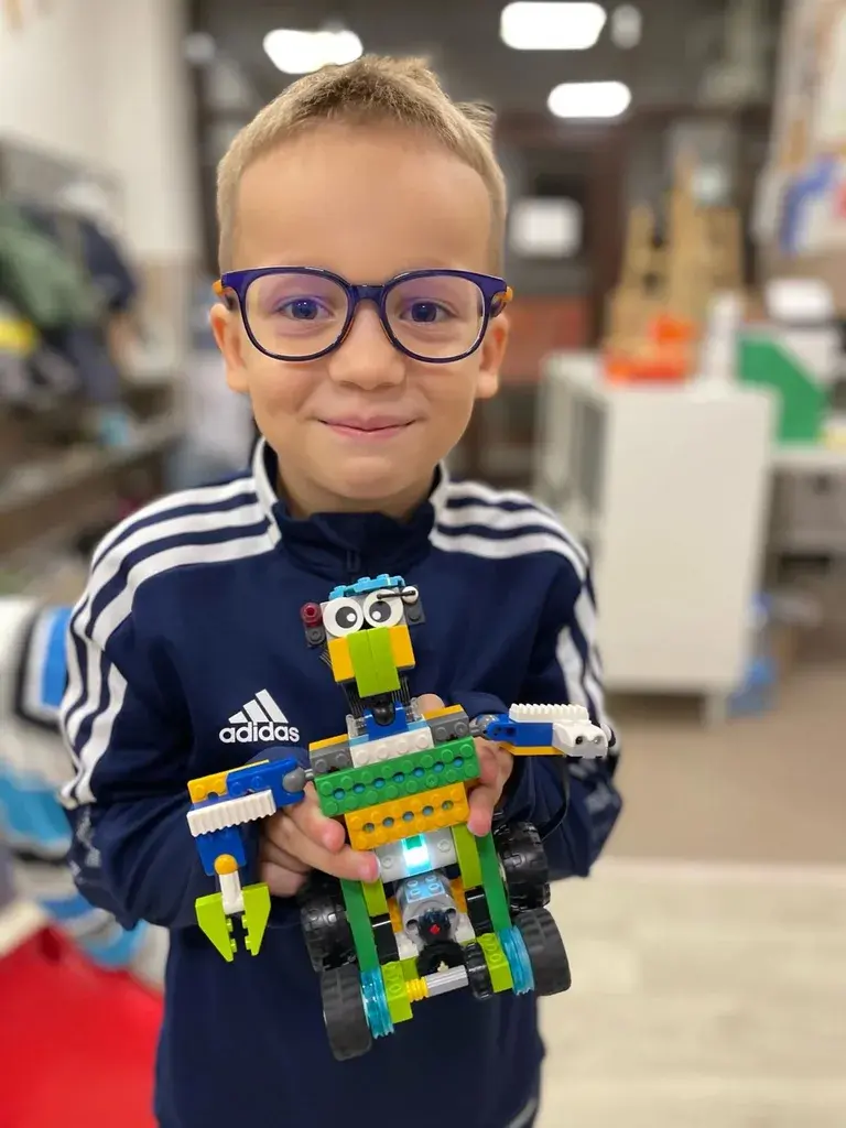 Ученик RoboCore держит собранного LEGO-робота