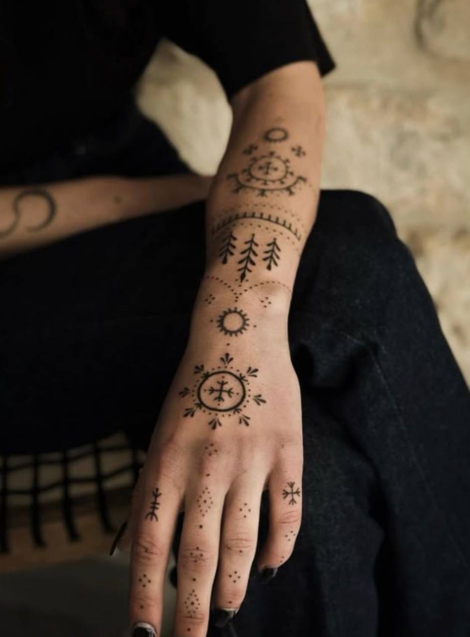 Татуировка с северными символами на кисти и предплечье