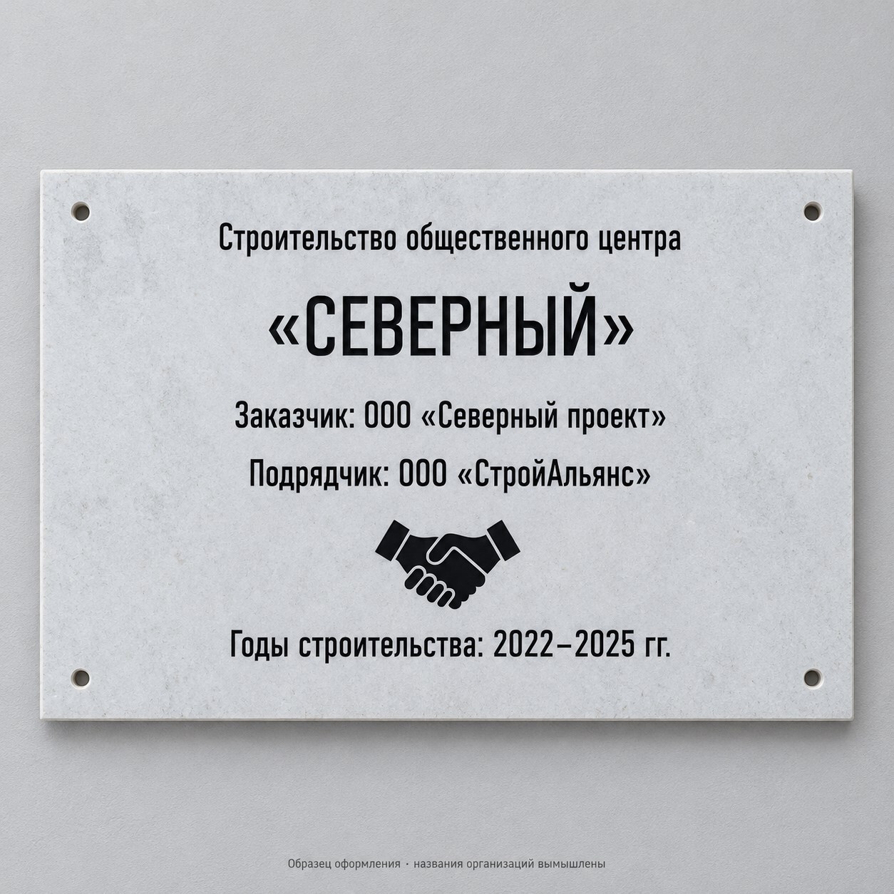 Светлая информационная плита для здания с названием объекта, годами строительства и эмблемой рукопожатия. Названия организаций вымышлены.