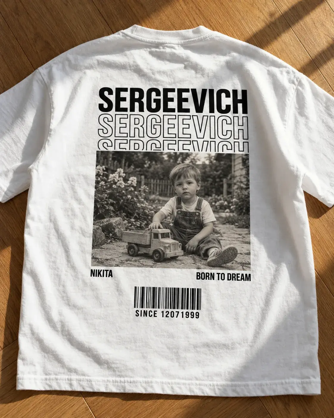 Футболка с повторяющейся надписью SERGEEVICH и чёрно-белой фотографией ребёнка с игрушечным грузовиком