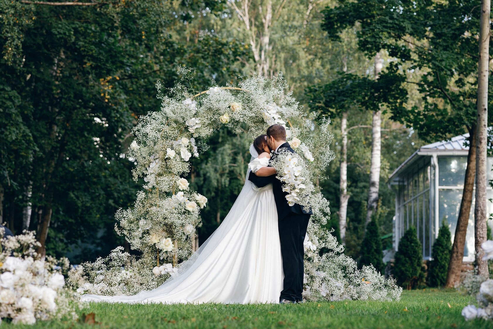 Выездная свадебная церемония на природе — молодожёны у цветочной арки, организация свадьбы под ключ