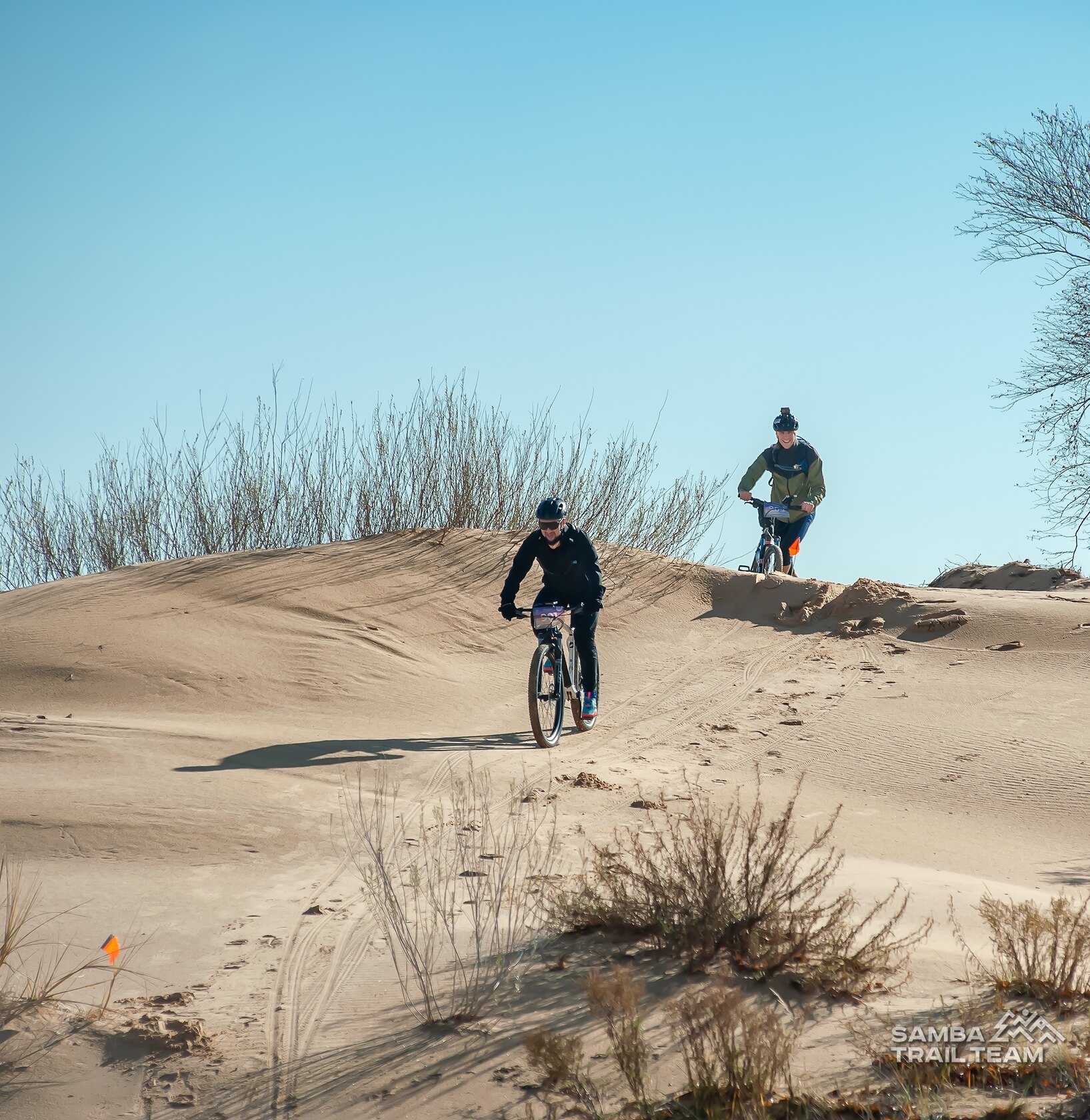 Участники Bike 28 спускаются на велосипедах с песчаного бархана