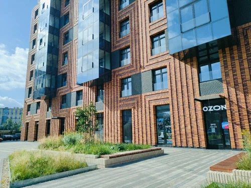 Кирпичный фасад ЖК Neva Haus с вывеской OZON