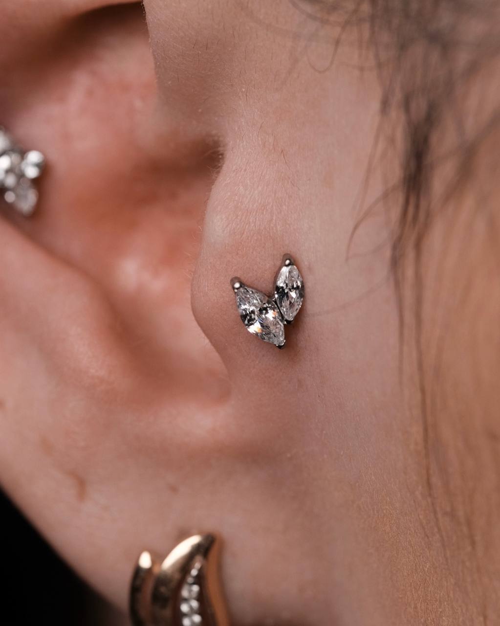 Пирсинг трагус с украшением крупным планом