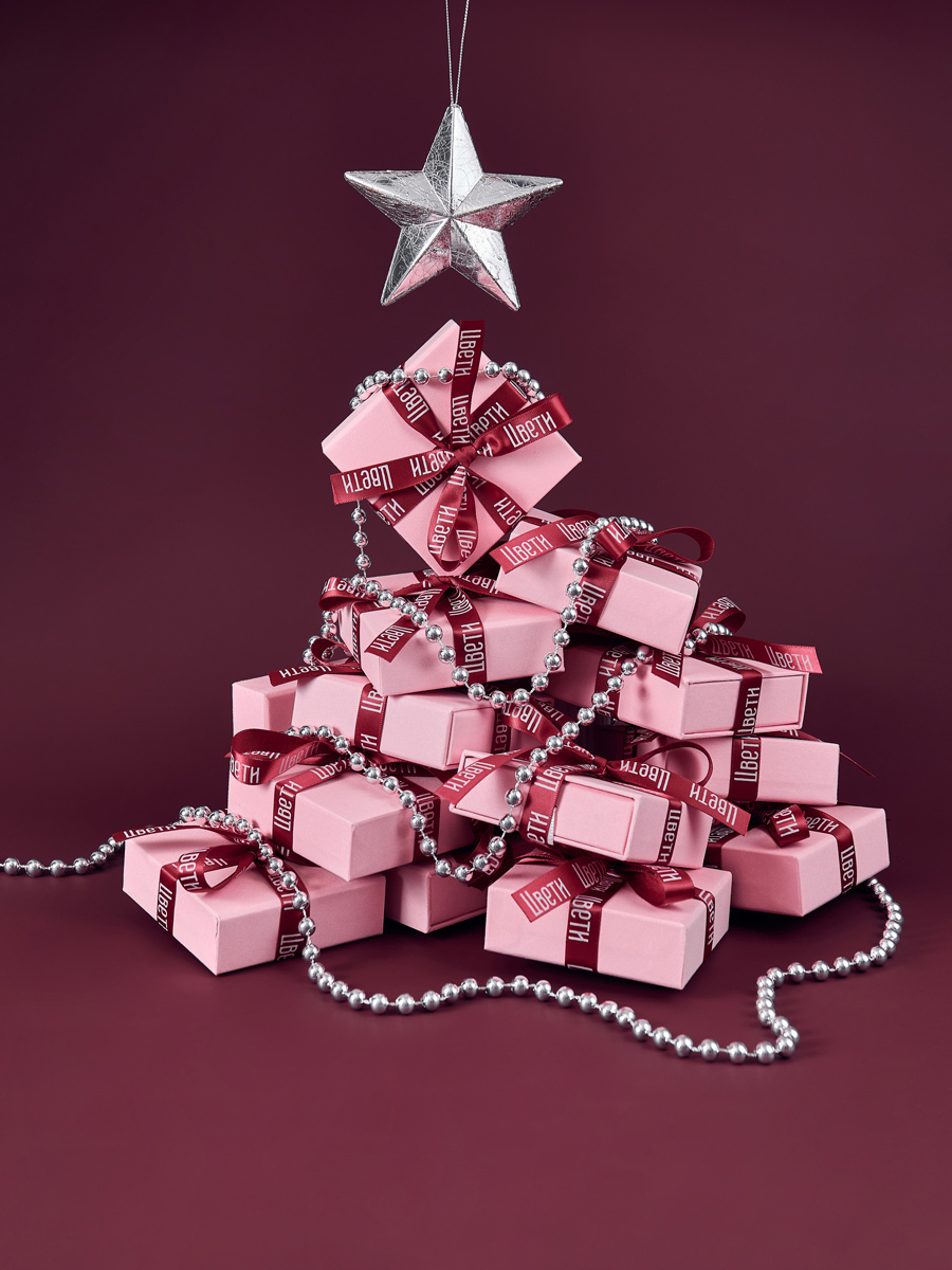 елка со звездой из подарком на красном фоне
