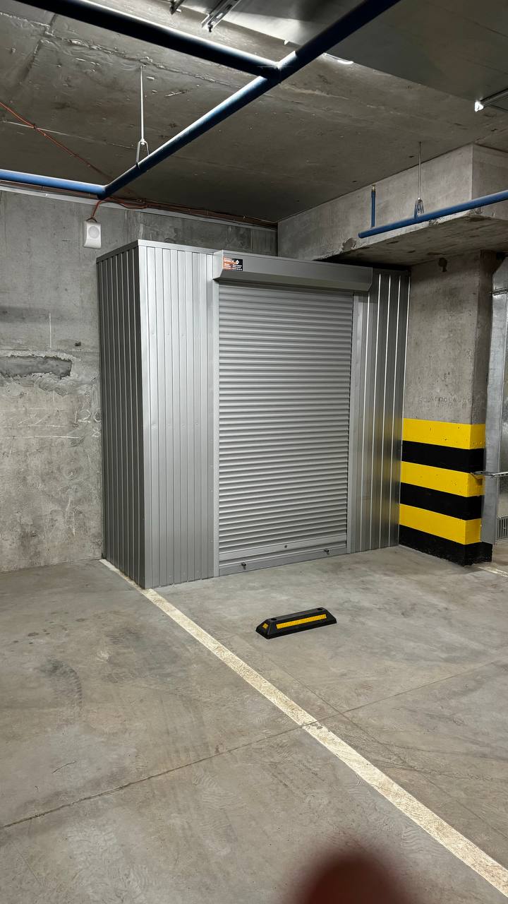 Роллетный шкаф-кладовая в паркинг (MaxParking) серебристого цвета из профлиста с металлическими полками для хранения шин, покрышек