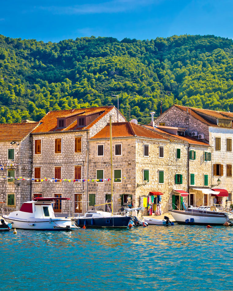 Boats and stone buildings line the coast of Stari Grad.