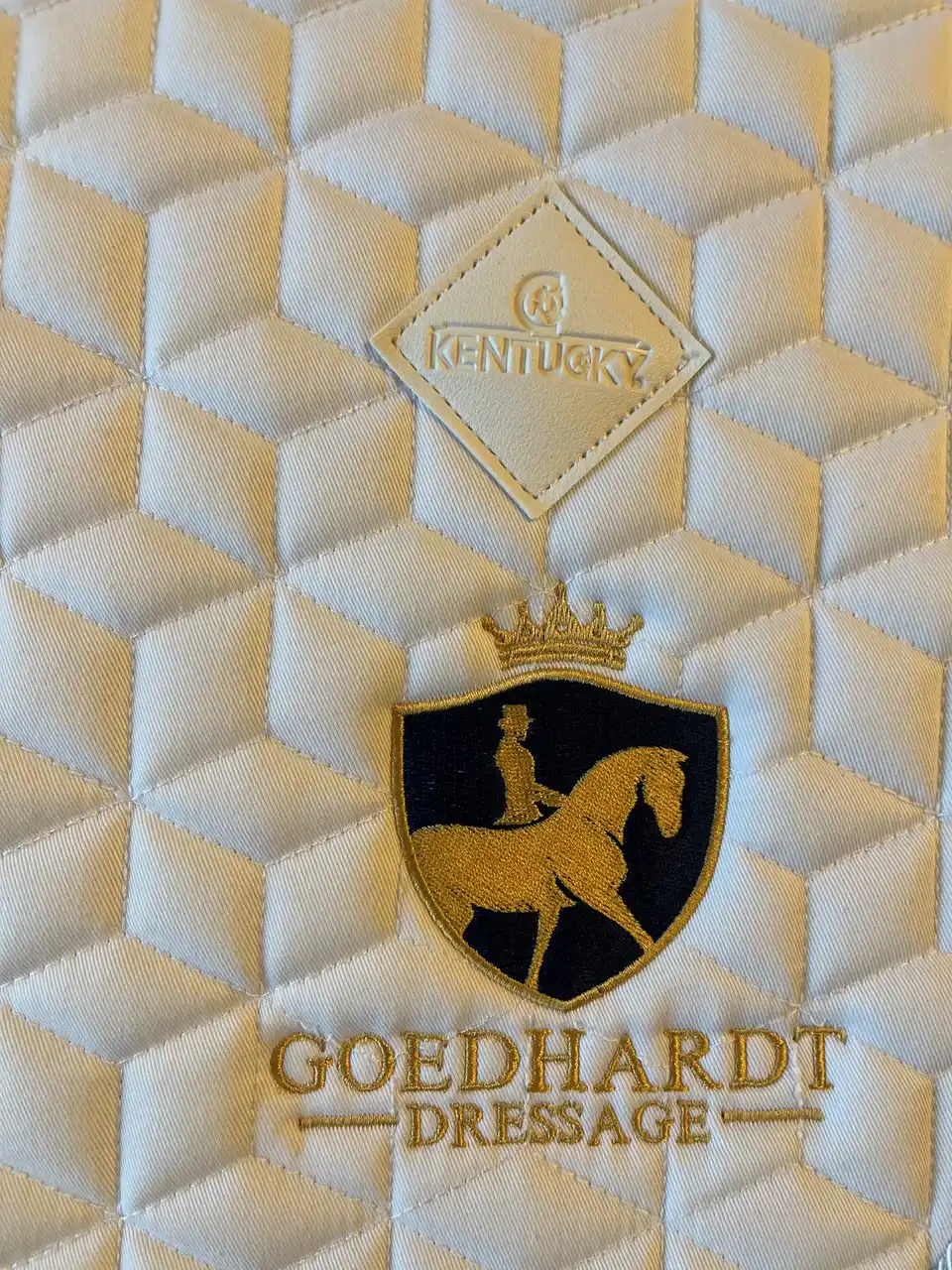 Embleem met tekst geborduurd op zadeldekje