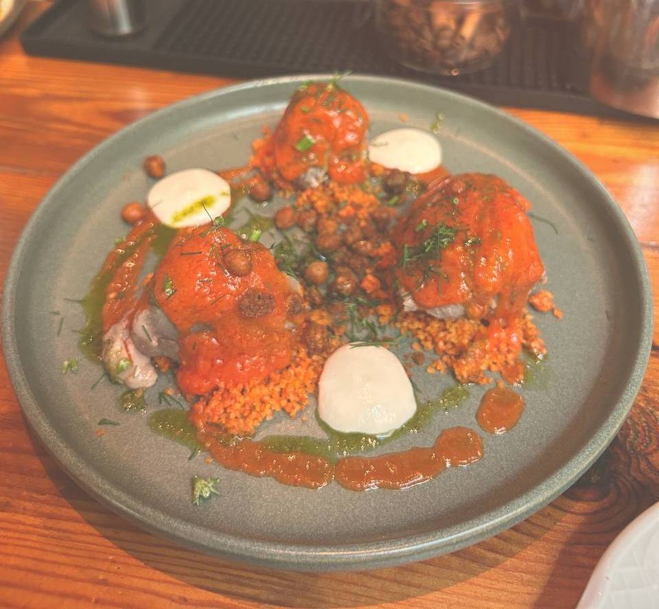 Meat glazed in vivid red pepper sauce, served on saffron couscous with yogurt at Sensi