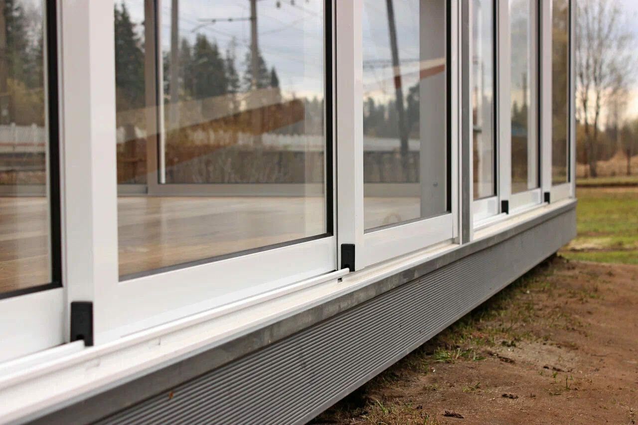 коттедж с панорамным остеклением. терраса с панорамными окнами. загородное остекление спб. веранда застекленная пвх с ламинацией темный дуб. загородный дом с панорамными окнами.