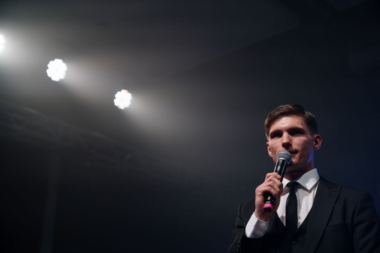 Павел с микрофоном на сцене зимнего корпоратива Брусники
