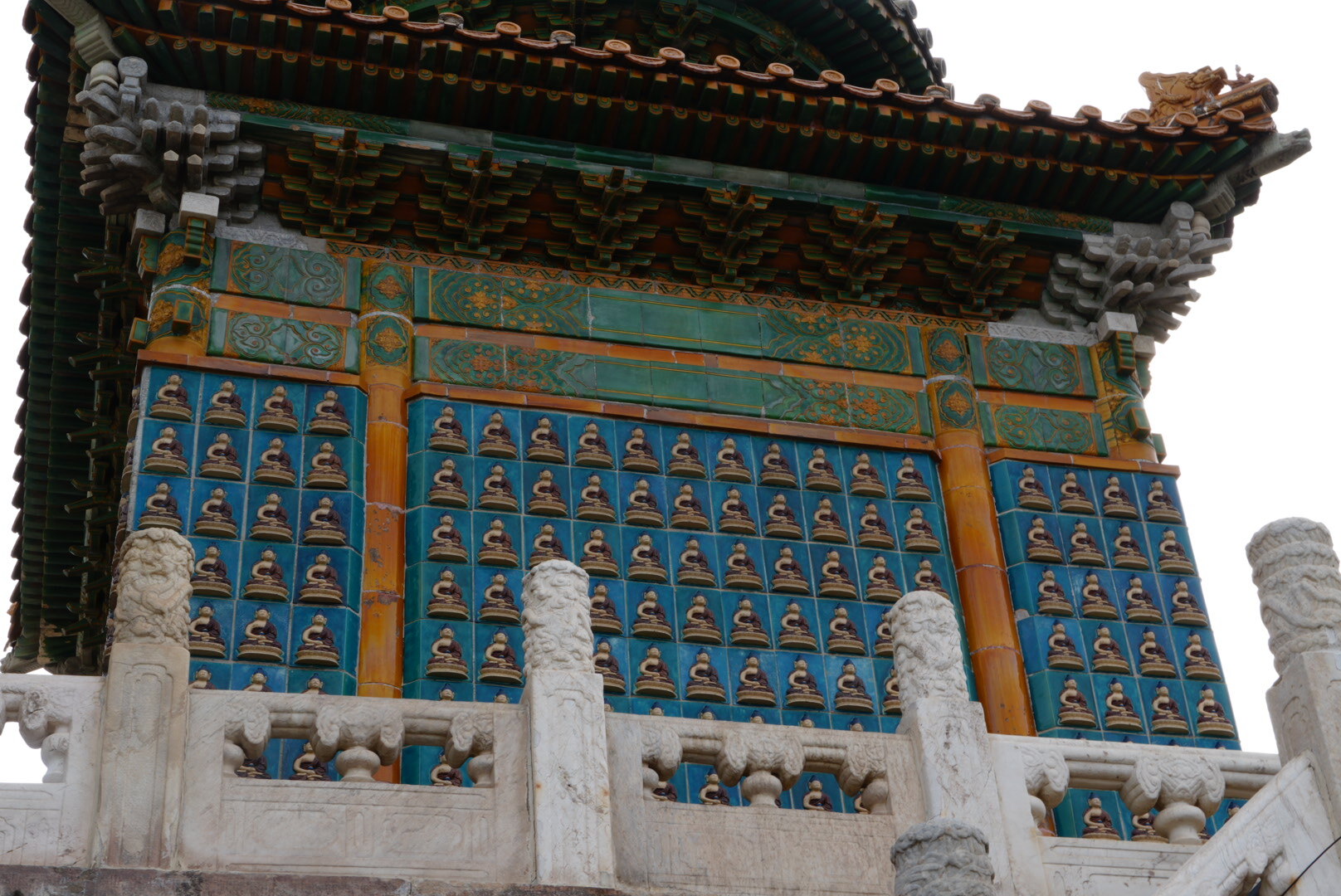 Храм в Пекине: яркая китайская пагода с голубой стеной, украшенной рядами статуэток Будды (Храм Неба)