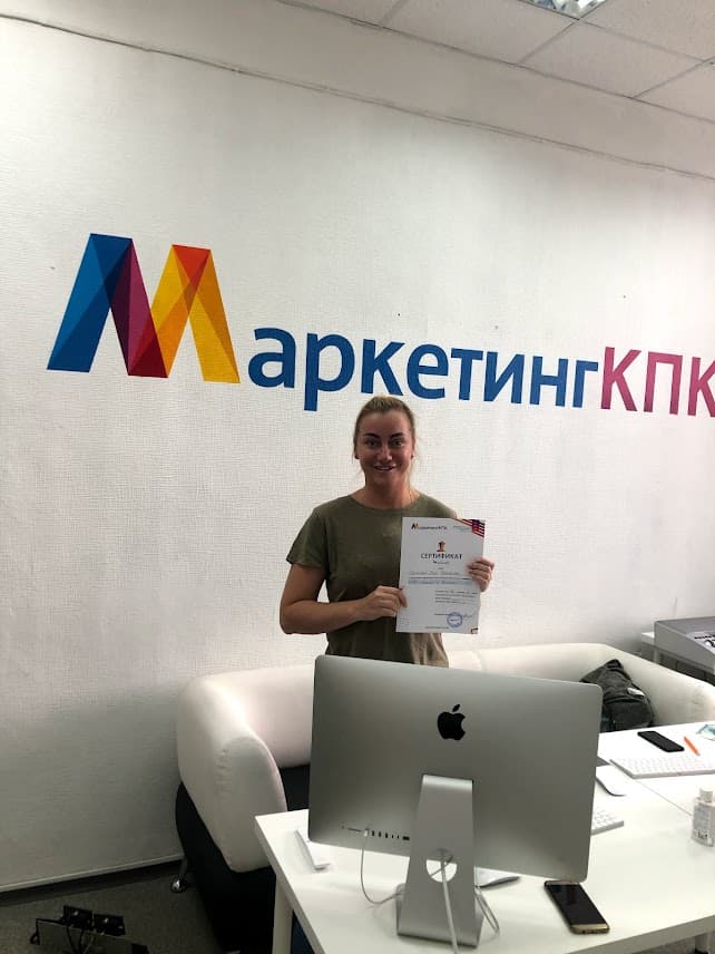 Выпускница с сертификатом у логотипа МаркетингКПК