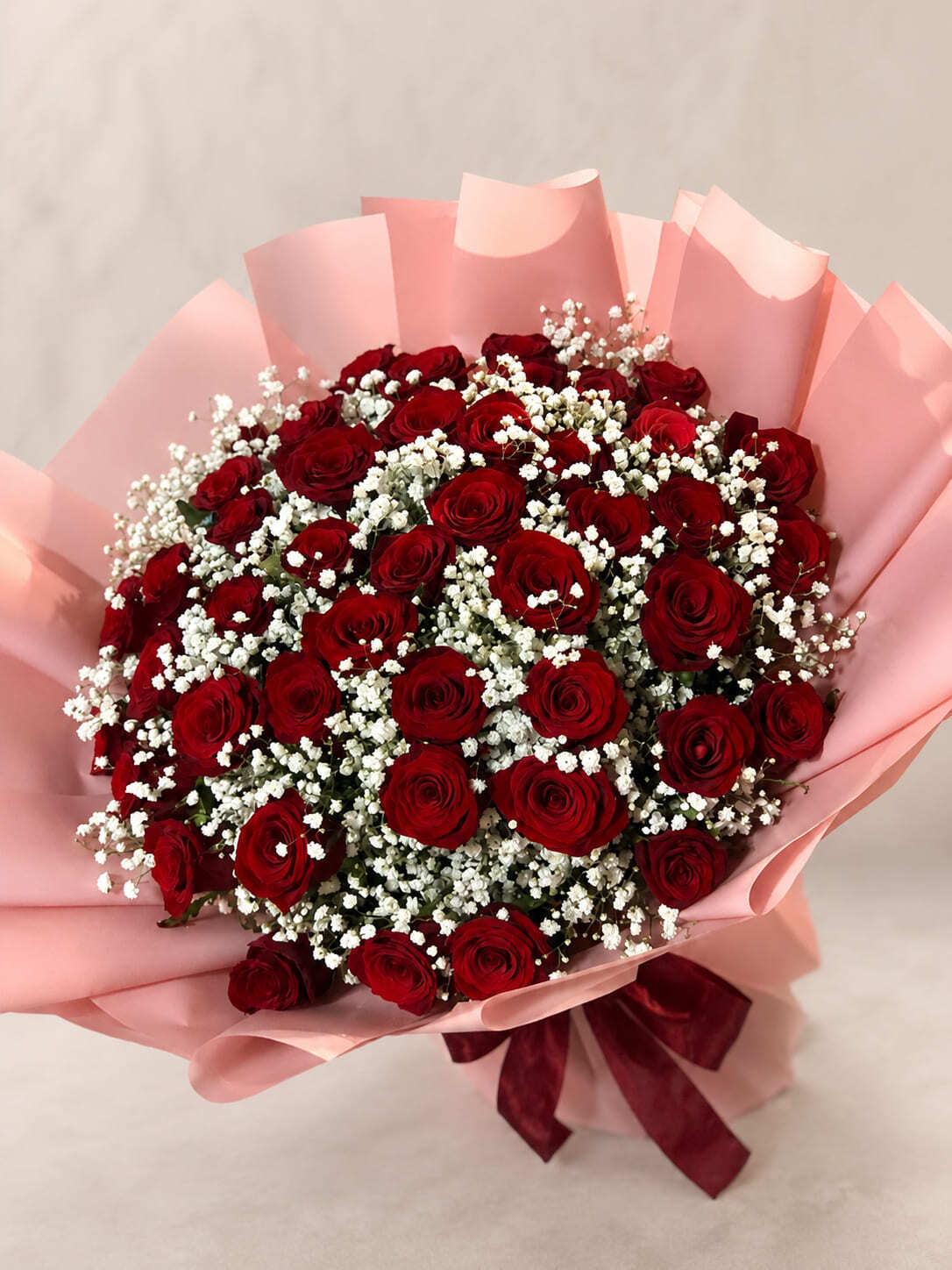 Luxury red rose bouquet with baby breath flowers in pink wrapping for flower delivery in Rabat Morocco