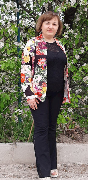 Актуално дамско сако с щампа на цветя и черна блуза и панталон 