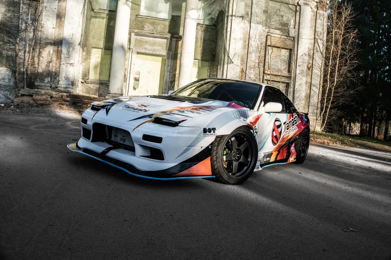 Nissan Tamashi — белый спортивный автомобиль с красной, оранжевой, голубой и чёрной ливреей