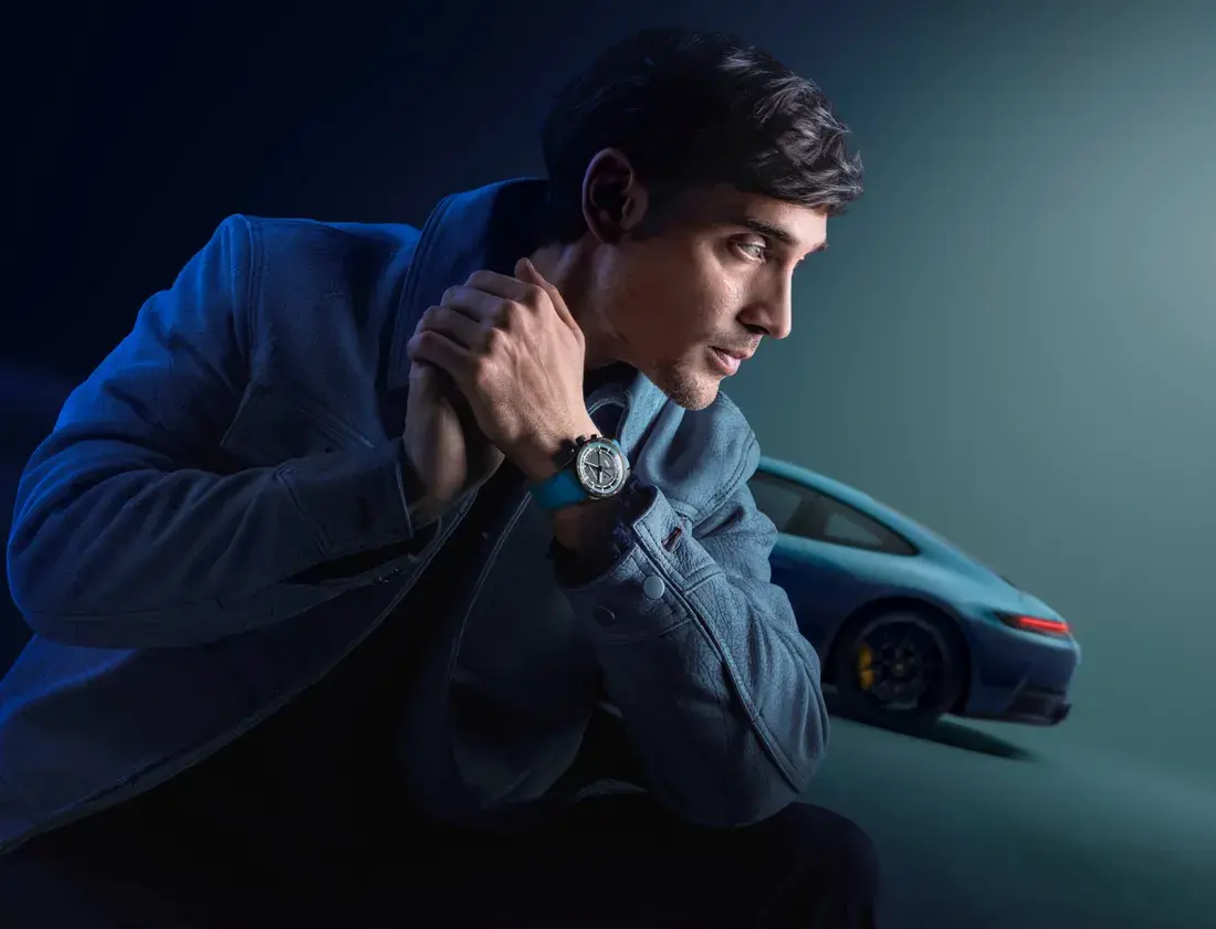 Мужчина с часами Porsche Design на фоне Porsche