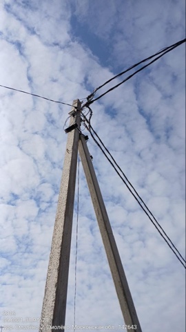 Установленная опора ЛЭП в деревне Смолево, Московская область, на фоне неба
