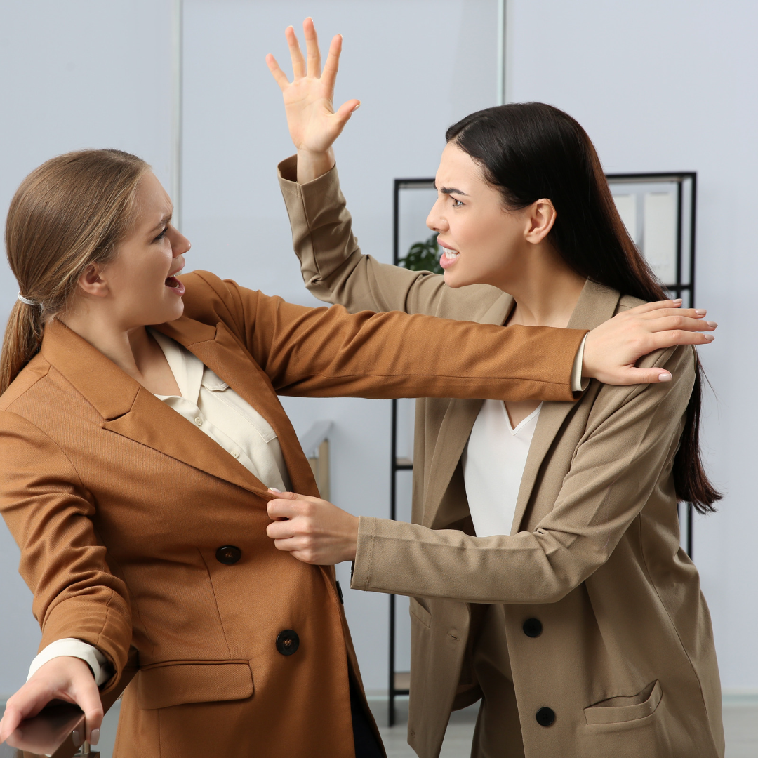 Two caucasian women figting with one grabbing the jacket of the other and with her hand raised and the other trying to push her back
