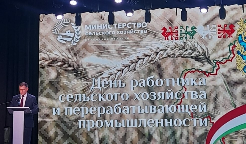 Праздничное изображение с символами аграрной отрасли: колосья, трактор и улыбающиеся механизаторы на фоне убранного поля