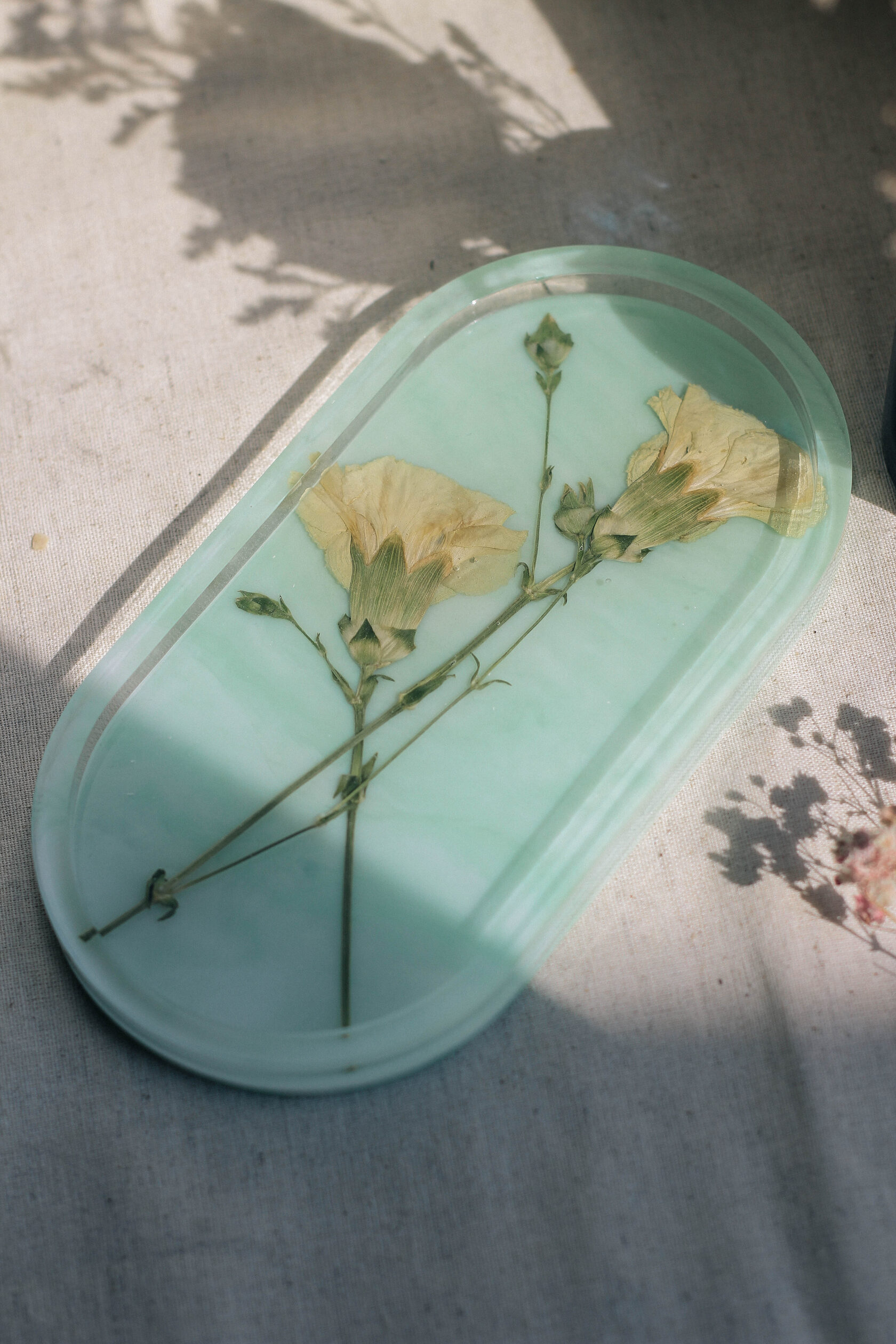 Овальный подиум из эпоксидной смолы зеленого цвета с натуральными цветами