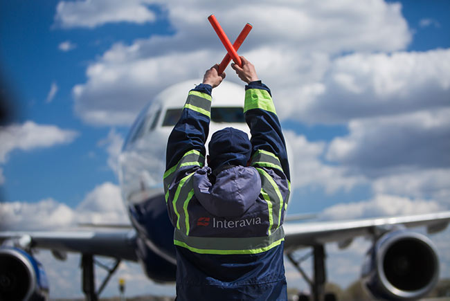 співробітник дає сигнали літаку