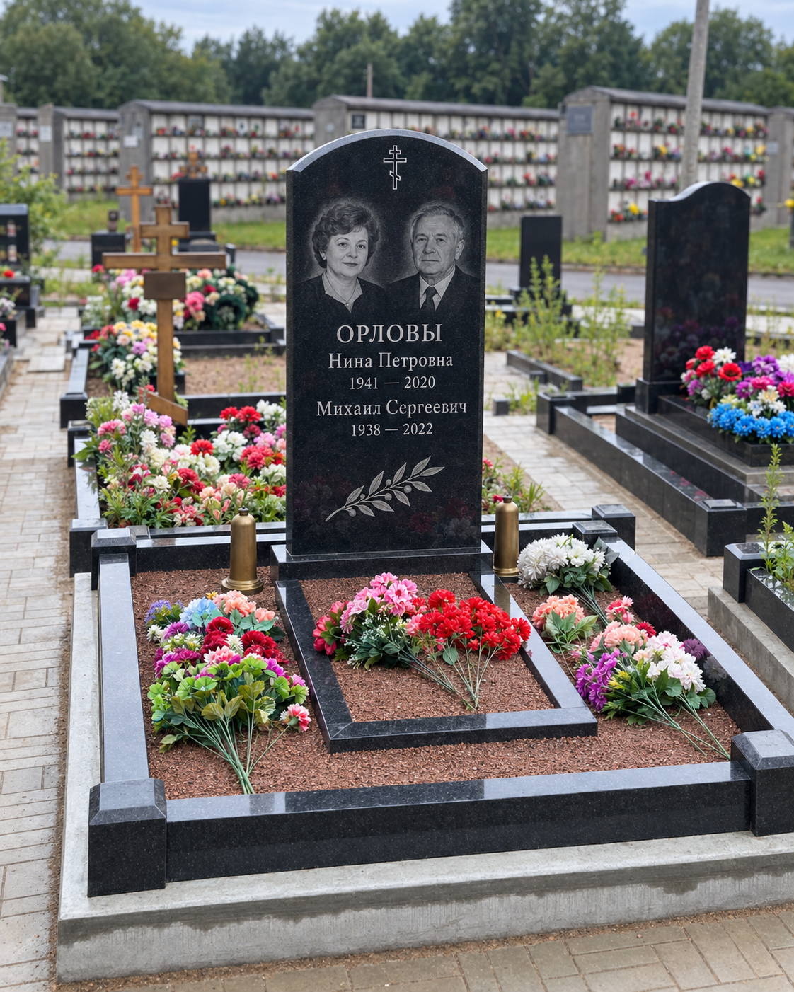 Семейный памятник с двумя портретами после установки на участке. Имена, даты и портреты изменены.