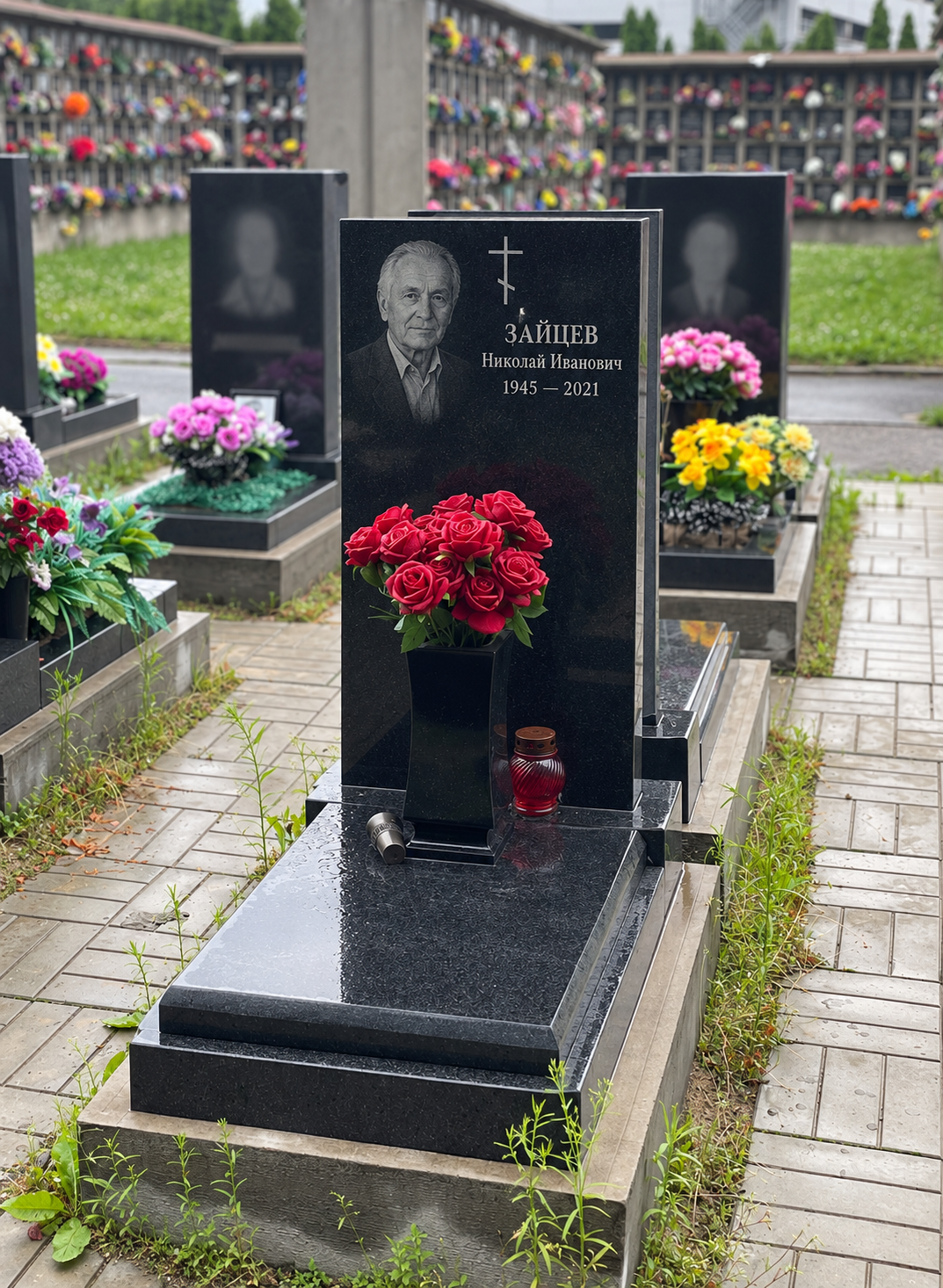 Памятник с цельной надгробной плитой после установки на участке. Имена, даты и портреты изменены.