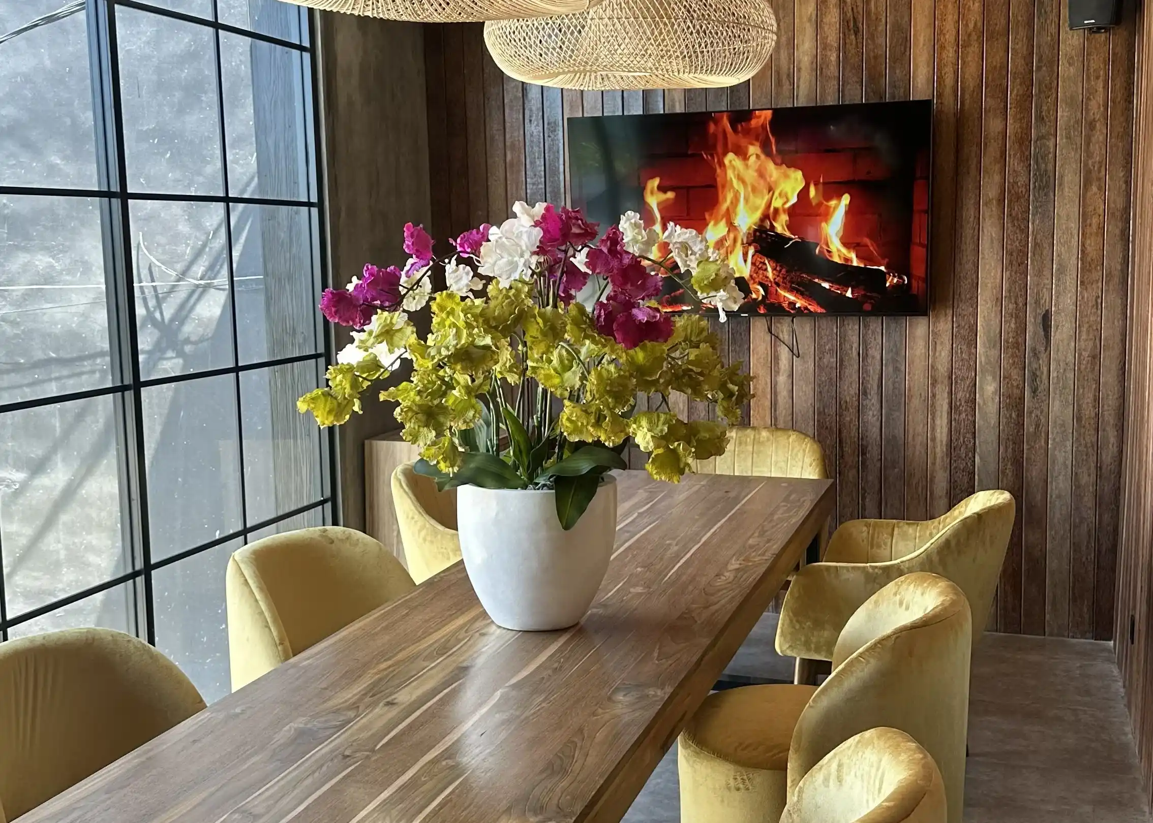 Private dining room at Eden Uluwatu with a wooden table, velvet chairs and fireplace screen