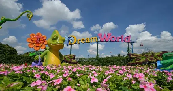 Объёмная вывеска Dream World над цветником, фигура хамелеона и канатная дорога парка