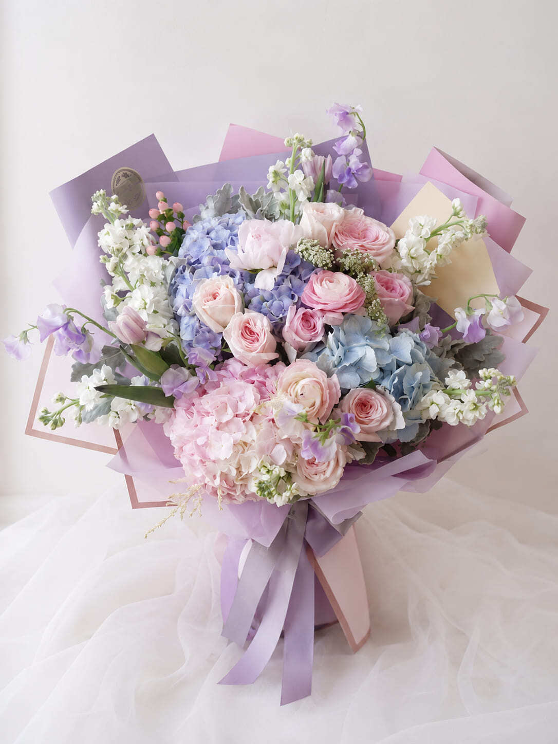 Luxury pastel bouquet with pink roses blue hydrangeas and lavender wrapping for flower delivery in Rabat Morocco
