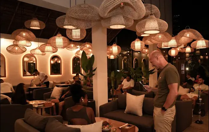 A busy and social atmosphere under hanging woven lamps at Eden Hookah Club Canggu, a top destination for what happens in Bali on Wednesday.