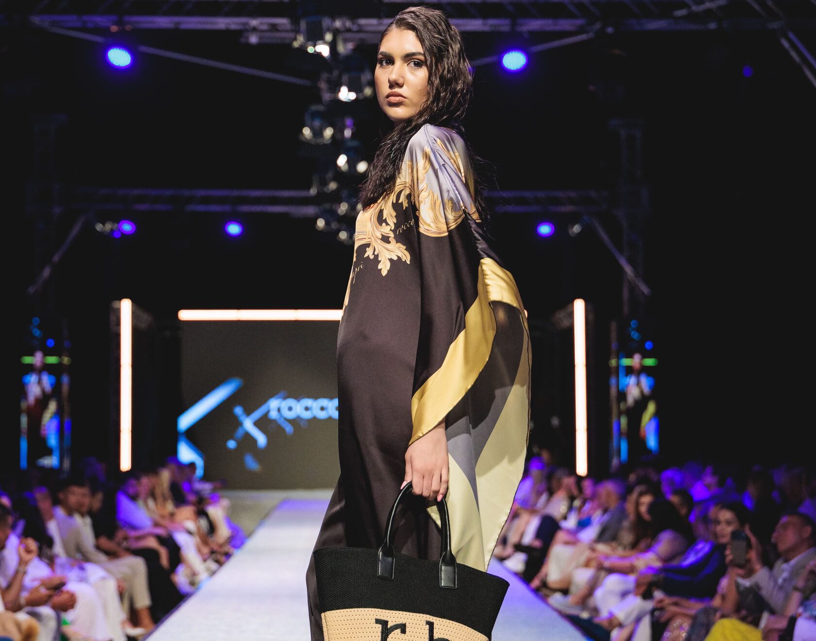 Красив модел позира за снимка облечена в рокля от Roccobarocco на Summer Fashion Weekend.