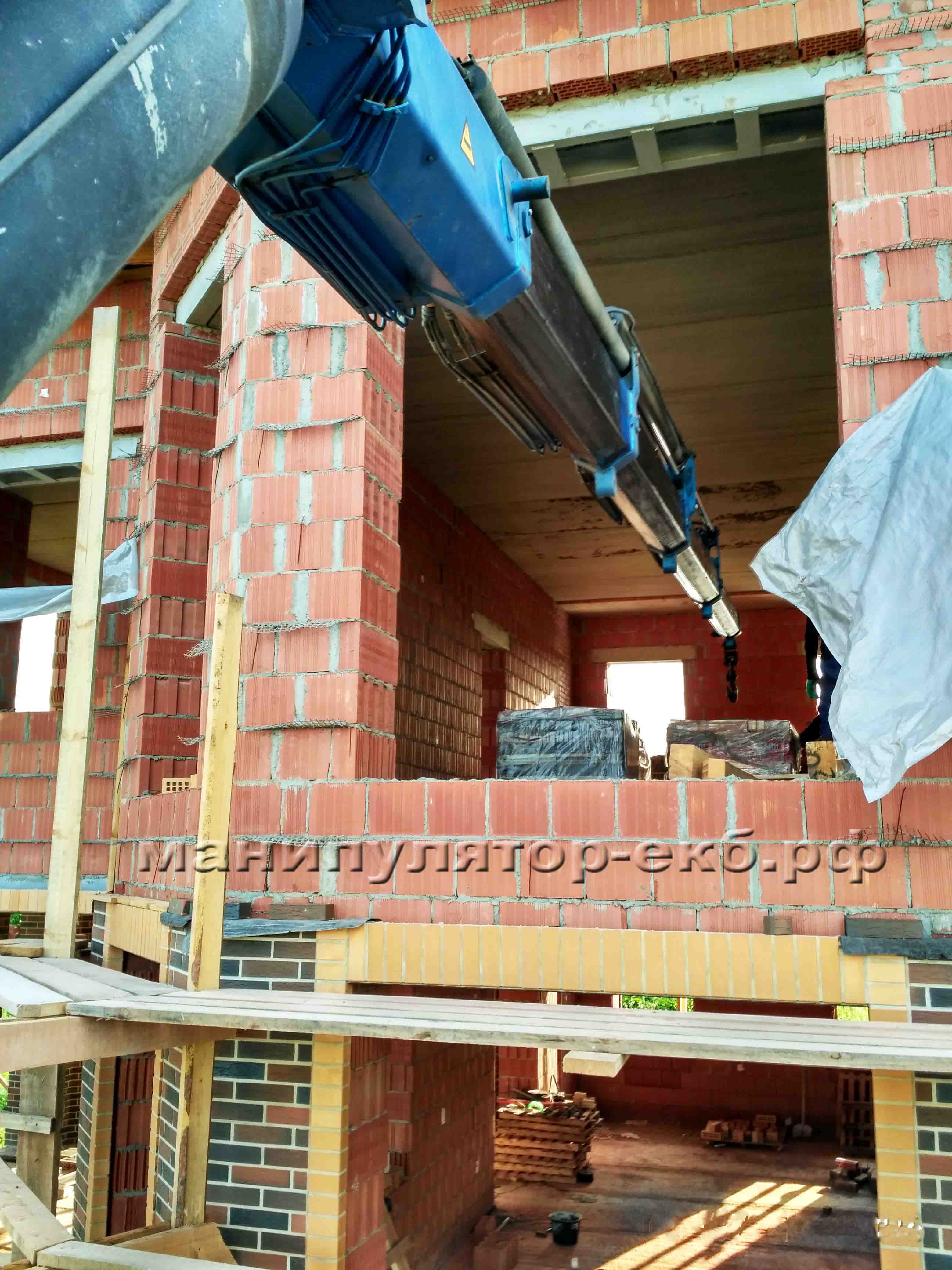 Подача манипулятором кирпича в проём