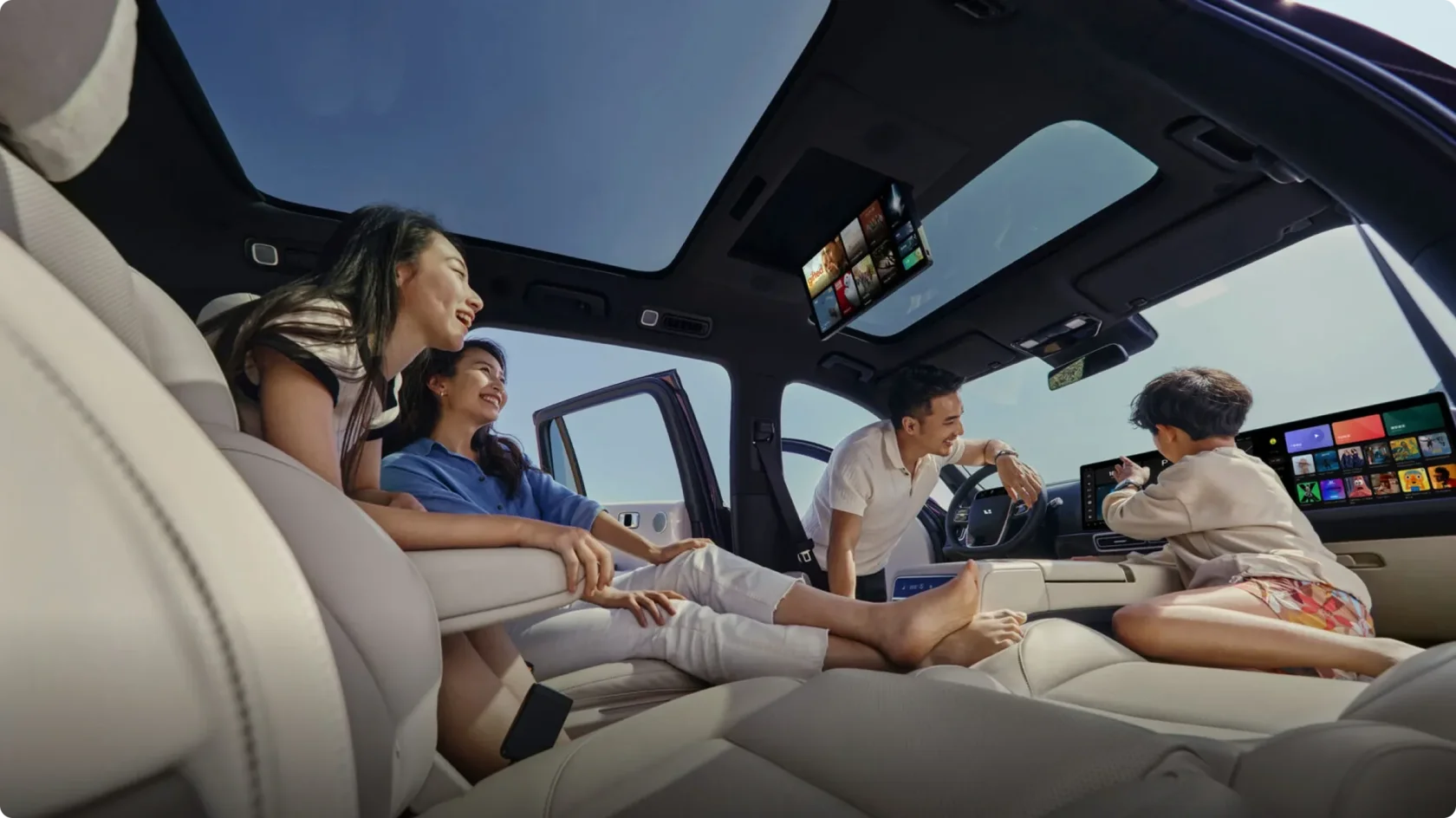 Семья в салоне Li Auto L9: панорамная крыша, потолочный экран и передние 15,7-дюймовые QLED-дисплеи, аудиосистема 7.3.4 для объемного звука.