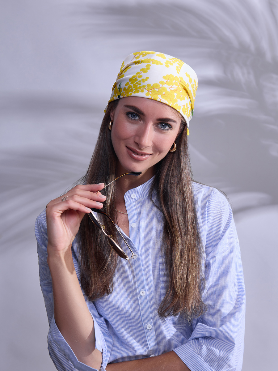 модель с желтым платком на голове на нейтральном фоне