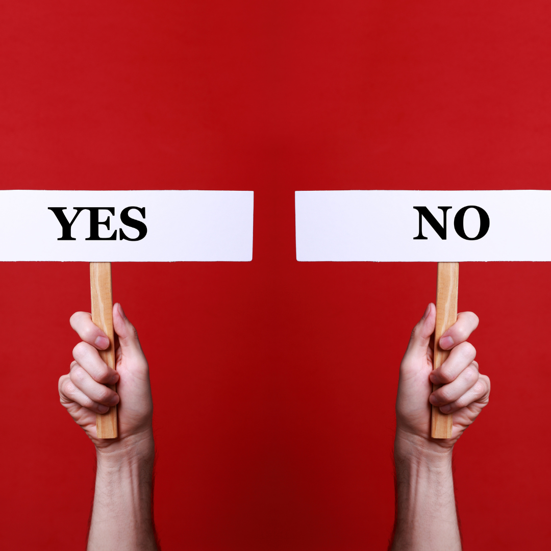 two hands holding signs that say yes and no