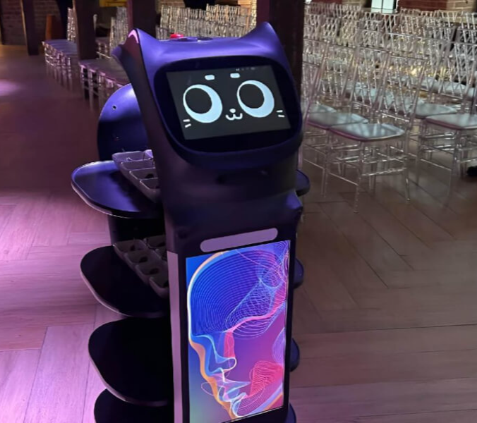 Робот-доставщик BellaBot везёт четыре подноса с блюдами