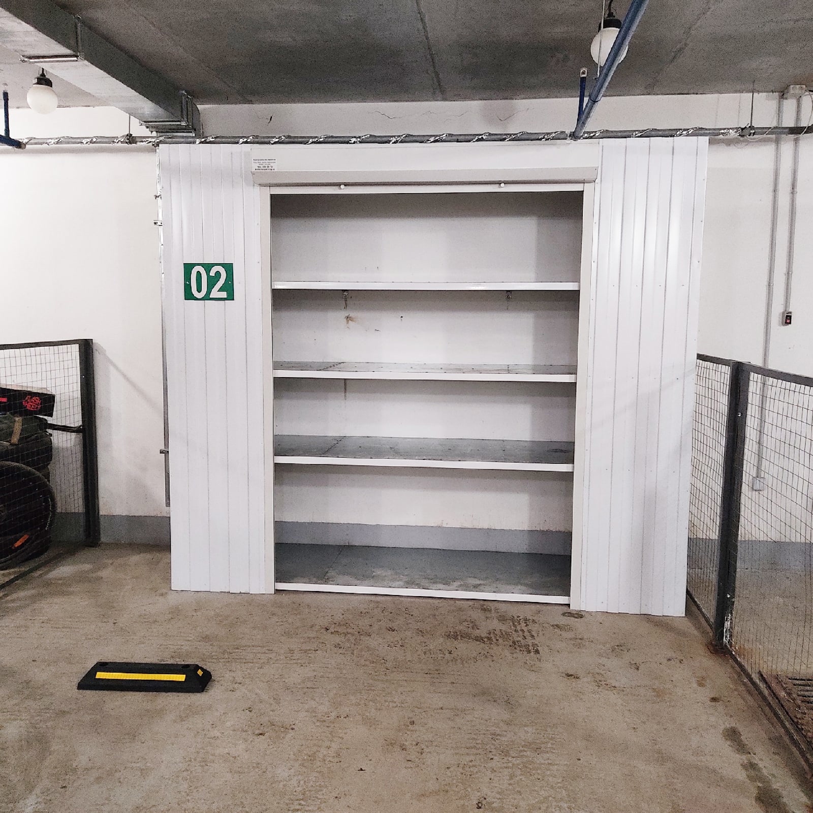 Роллетный шкаф-кладовая в паркинг (MaxParking) серебристого цвета из профлиста с металлическими полками для хранения шин, покрышек, сноубордов и лыж