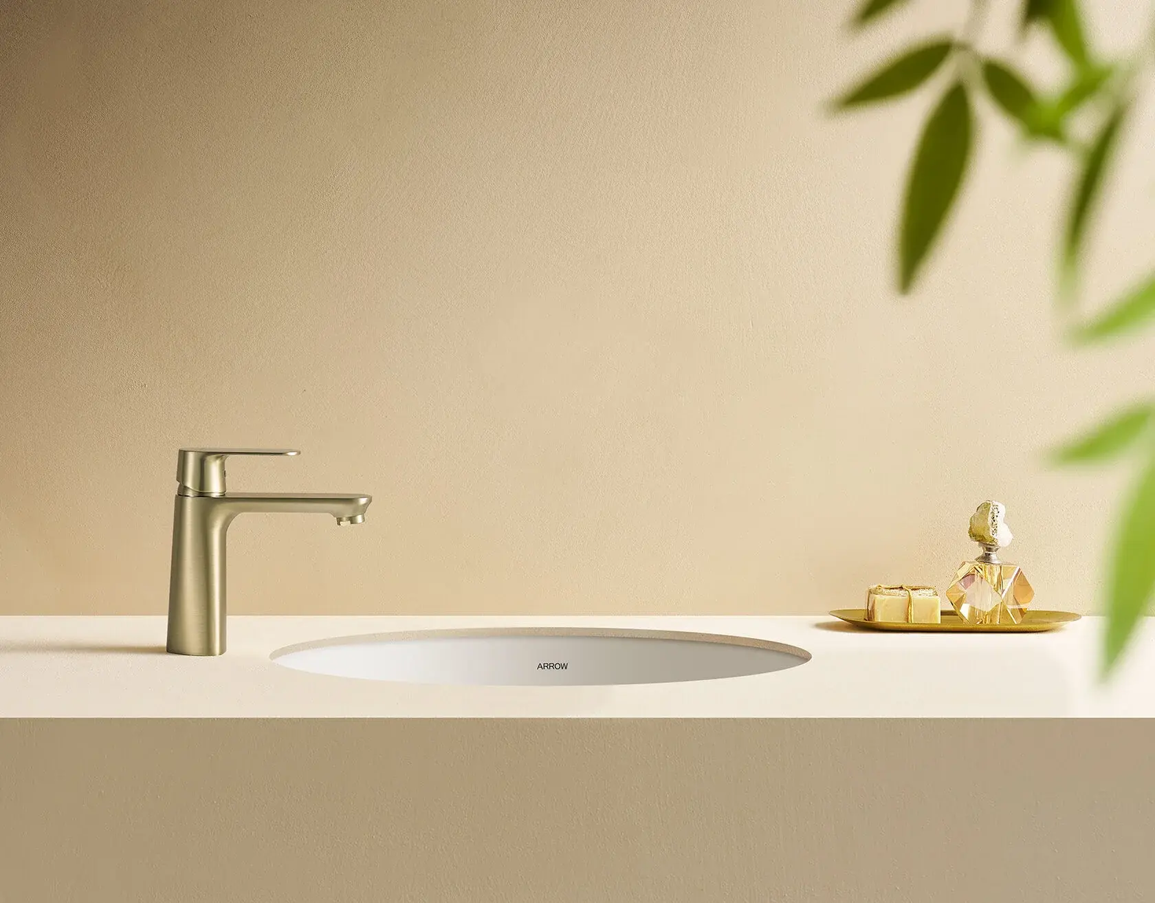 Сбоку матовый золотой смеситель в бежевом интерьере