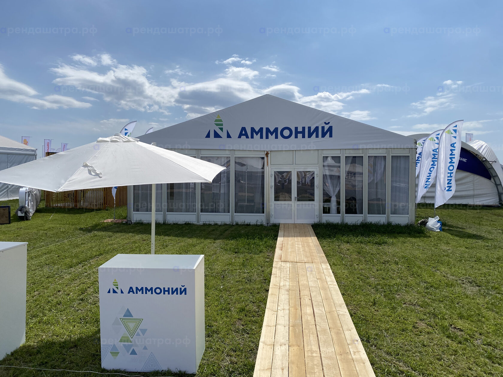 Всероссийский день поля 2023 — фасад павильона «Аммоний», дощатый настил к двери, зонт и стойка с логотипом