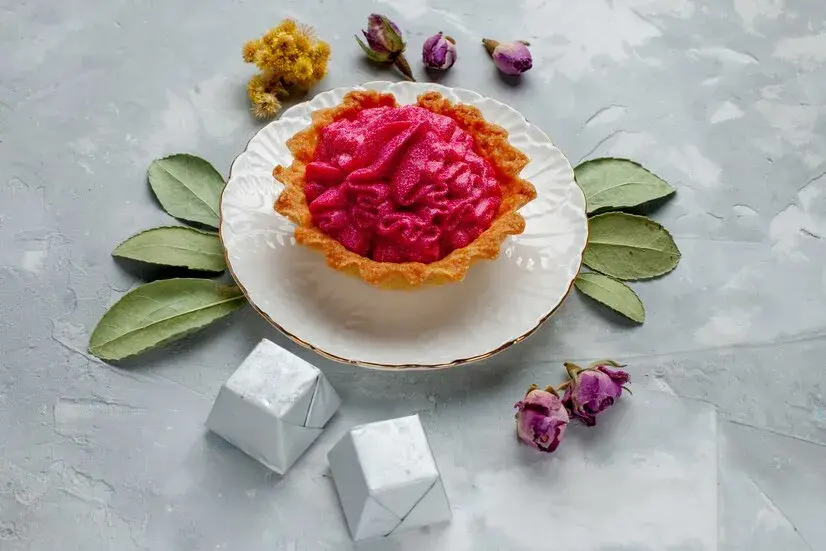 Яркий безглютеновый детский десерт — тарталетка с ягодным кремом, оформленная натуральными цветами, без сахара и пшеничной муки