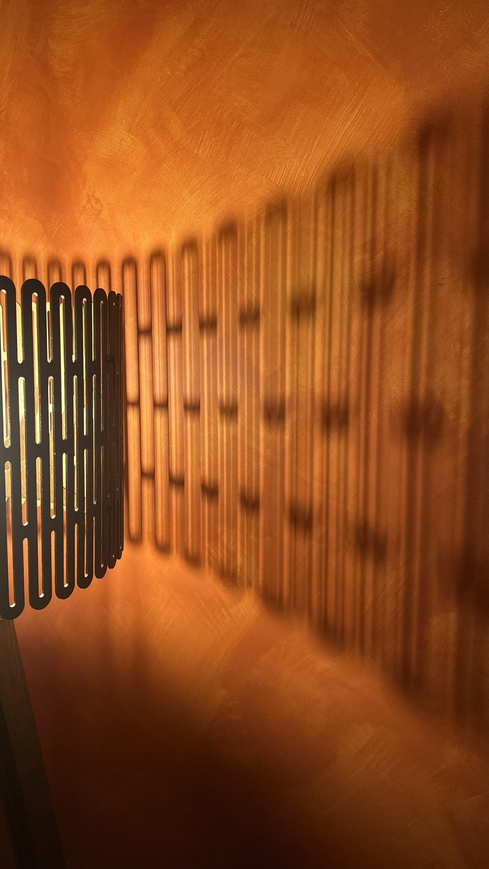 Дизайнерский торшер из ореха в массажной комнате студии ПАУЗА. Узор теней на стене создает особую расслабляющую атмосферу.