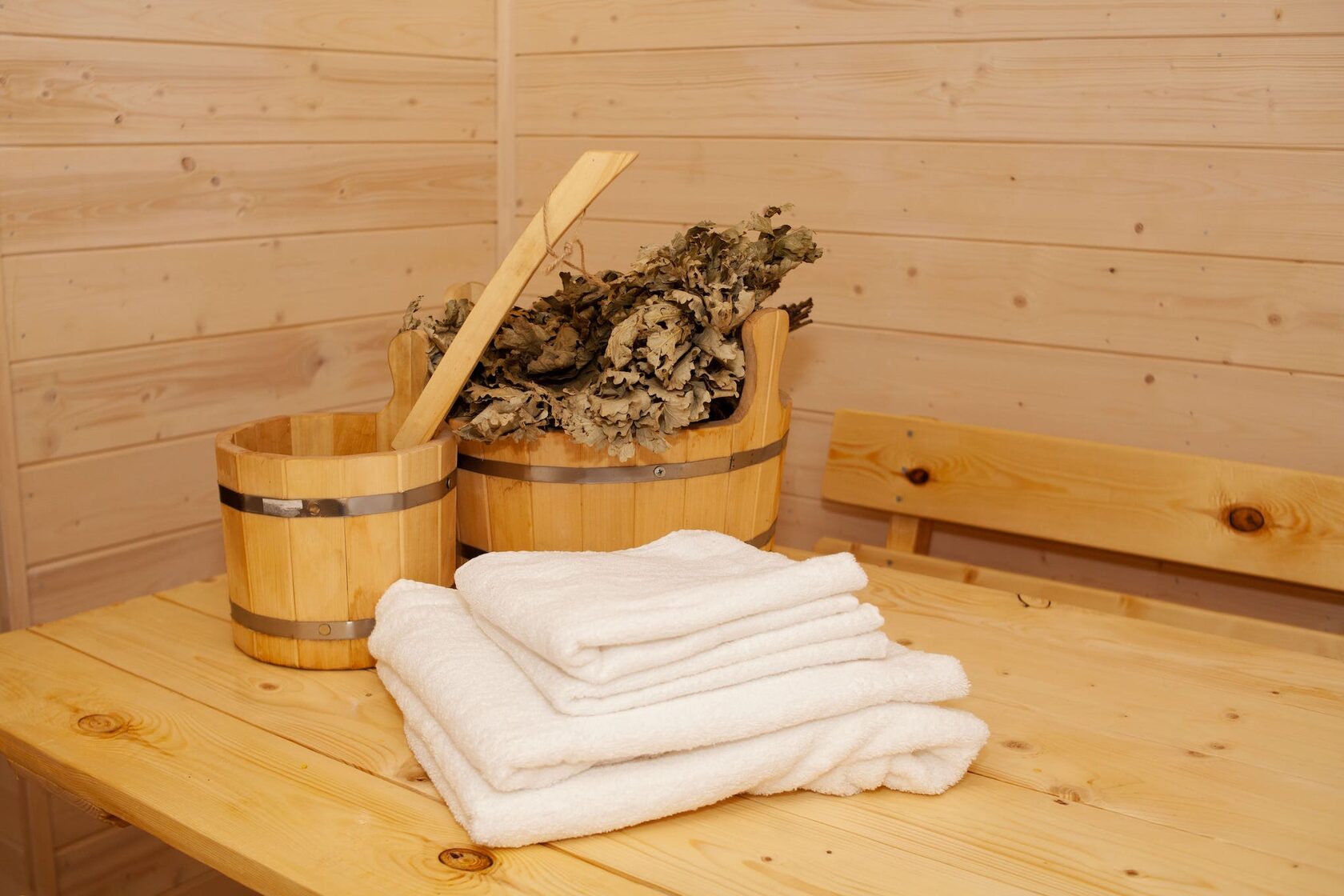 Деревянный ковш и веники в бане домика Aframe Happy — атрибуты для традиционных банных ритуалов