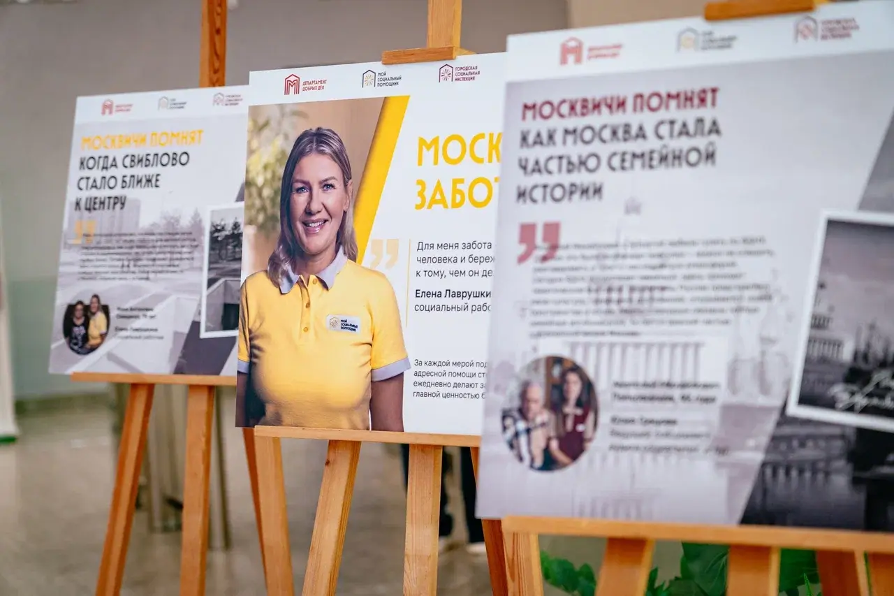 Стенды фотовыставки «Москва заботится. Москвичи помнят» ко Дню города в Департаменте труда и социальной защиты. На плакате изображена социальный работник службы «Мой социальный помощник» Елена Лаврушкина и личные истории пожилых москвичей
