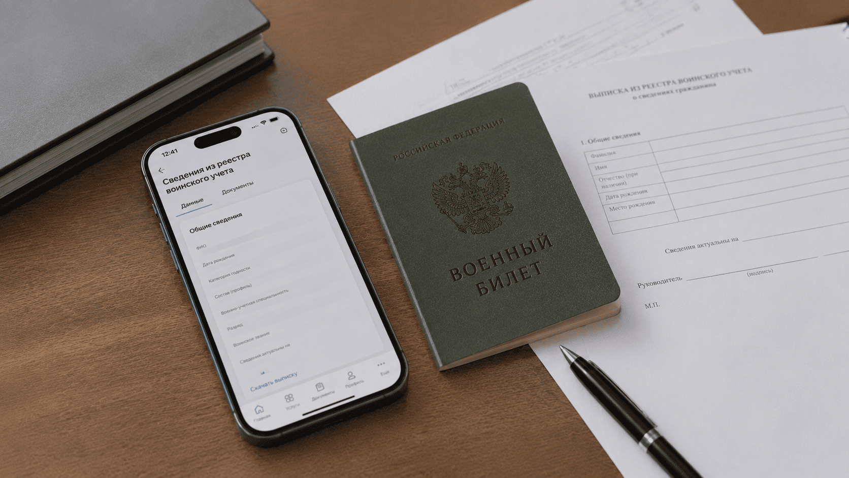 Смартфон с данными воинского учёта рядом с бумажным военным билетом