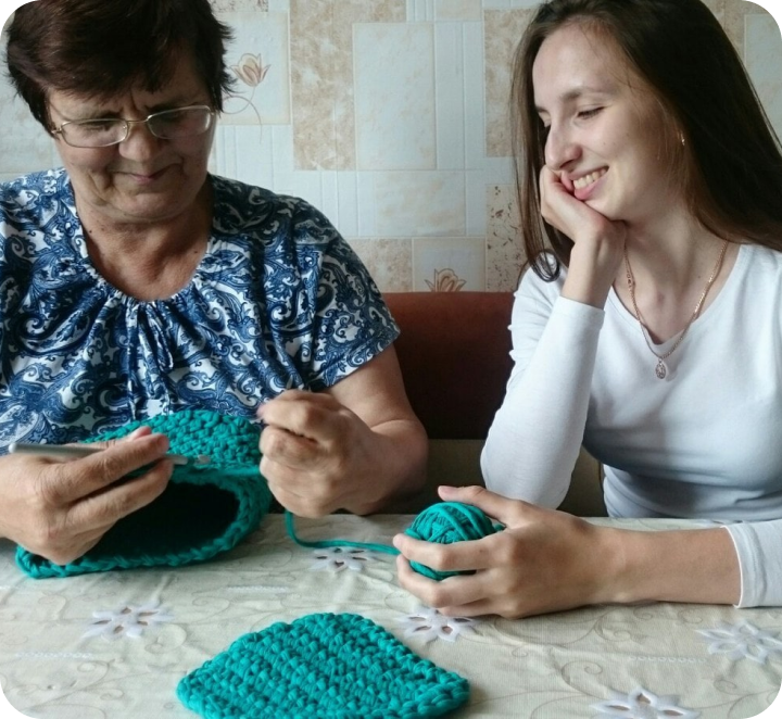 улыбающаяся девушка за столом с бабушкой 