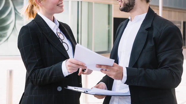 Free photo businessman and businesswoman holding documents in hands