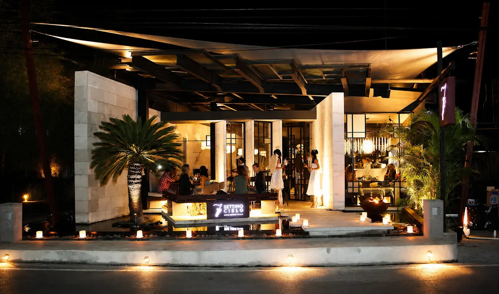 Cozy interior of Settimo Cielo restaurant in Seminyak, Bali, known for its handmade pasta and trendy, all-weather glass roof dining area.